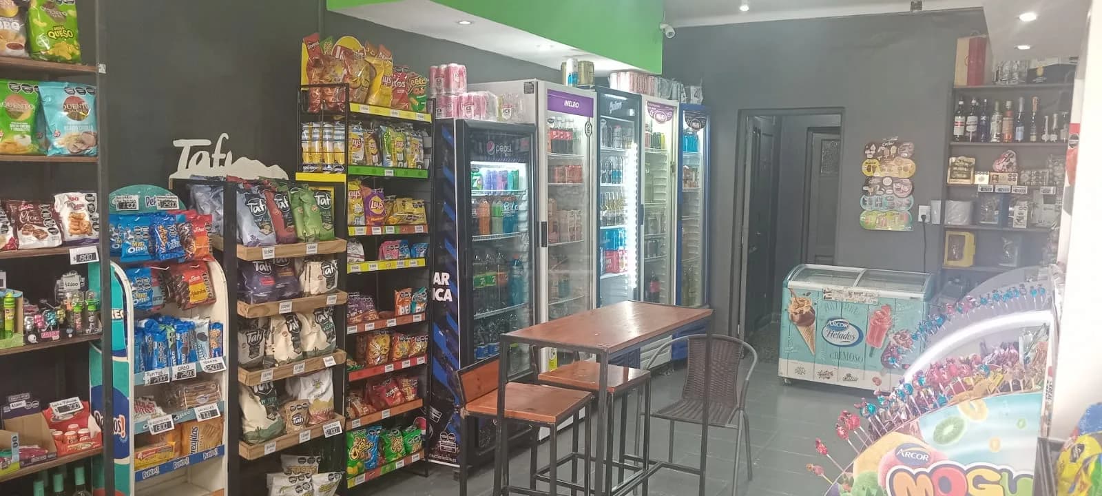 Interior de Open Plaza Drugstore con góndolas de golosinas, snacks y productos variados