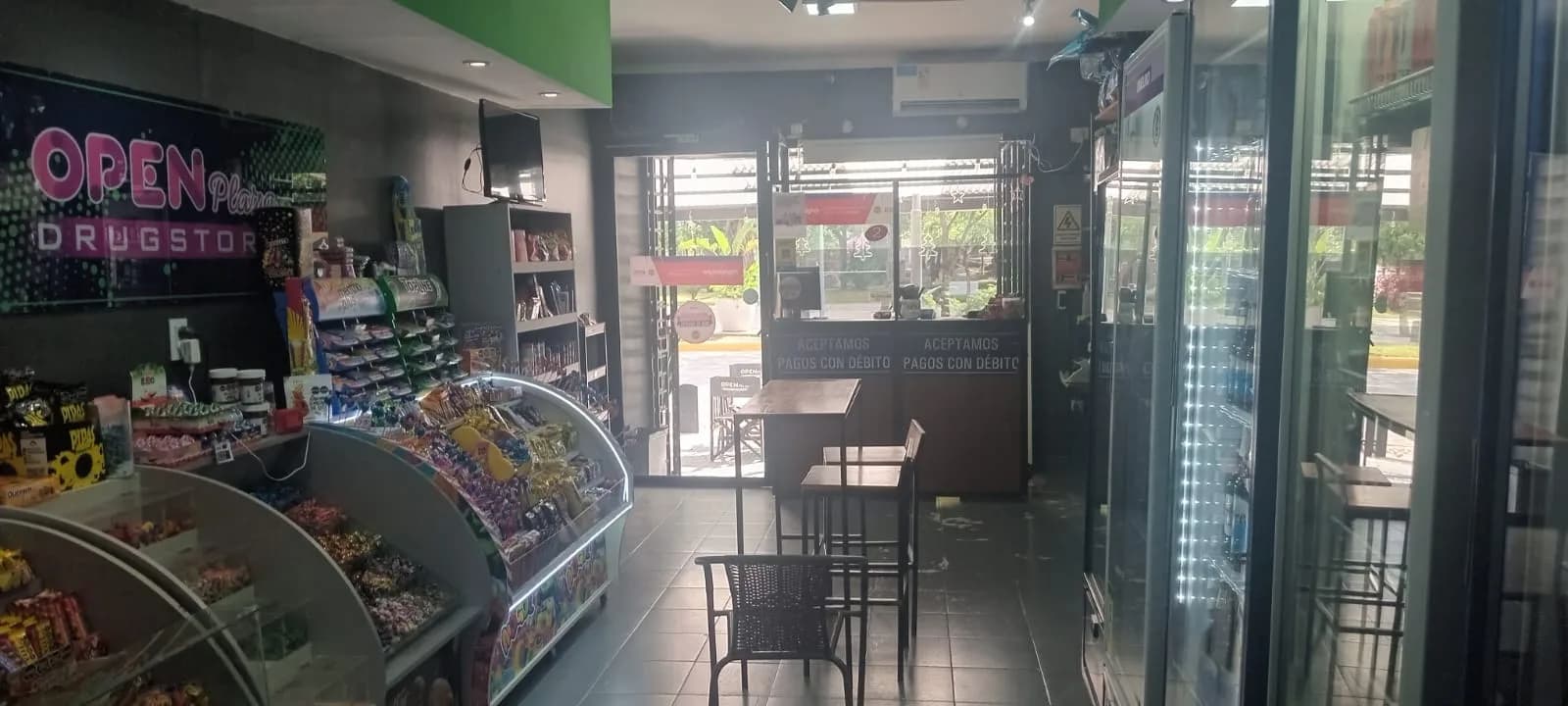 Góndola con golosinas, snacks y productos varios en Open Plaza Drugstore
